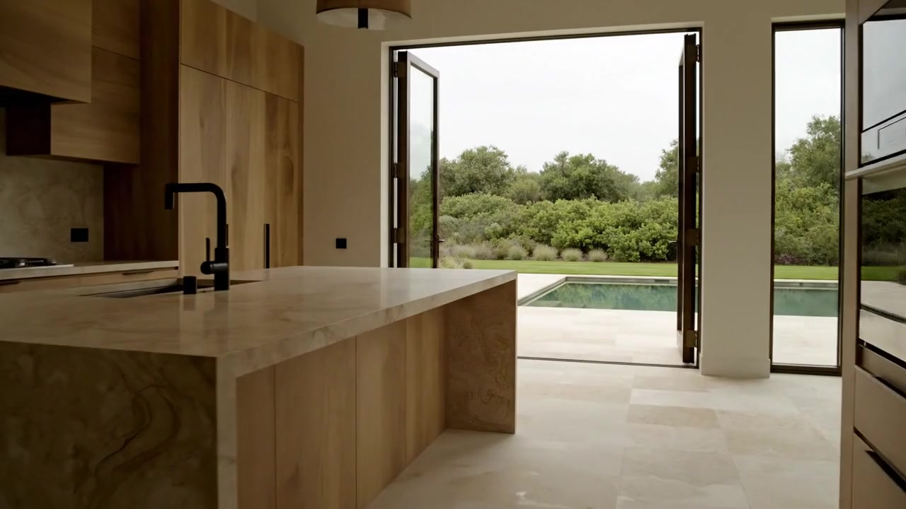Lizaz architectural concept: timber and stone kitchen opening onto a garden and pool